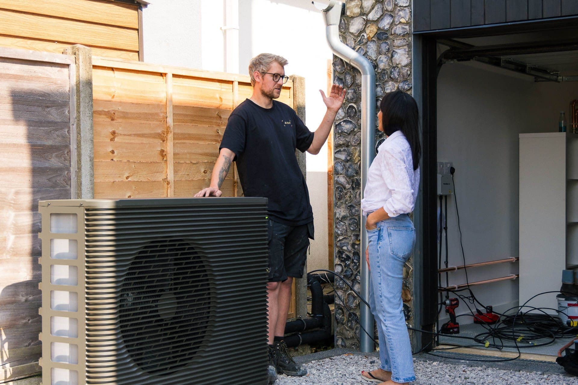 Aira technician and customer chatting next to an Aira air source heat pump