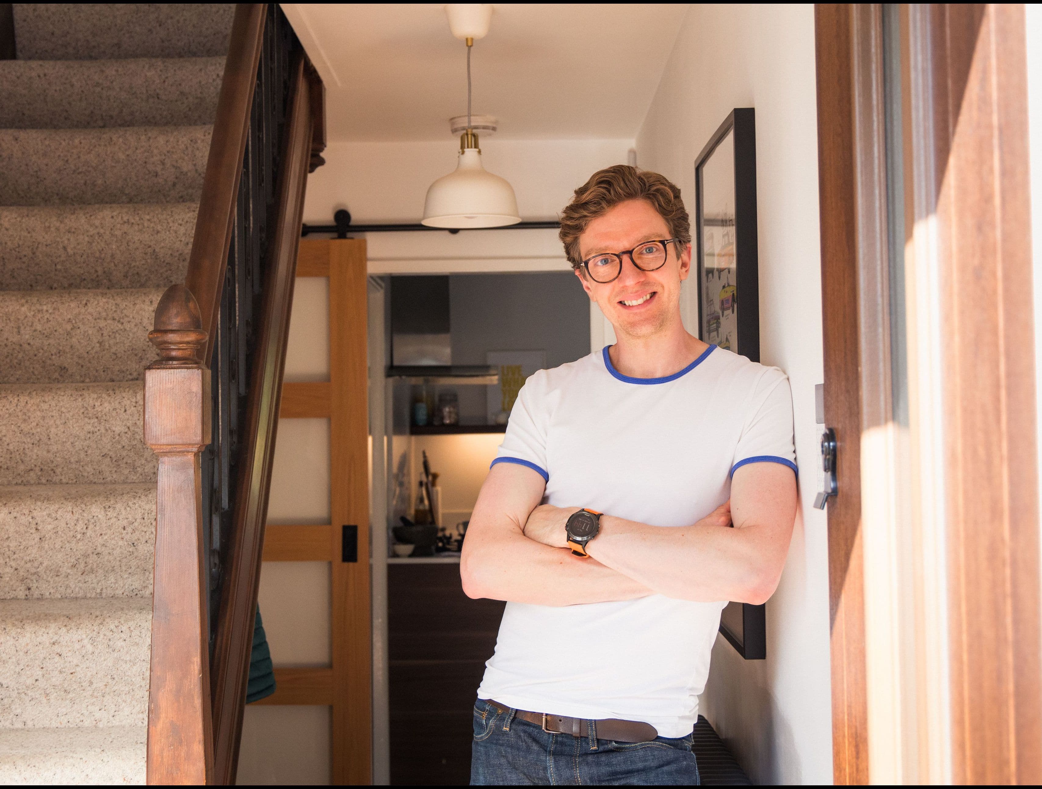 Man standing in his hallways with arms folded and smiling following an Aira Heat Pump Installation