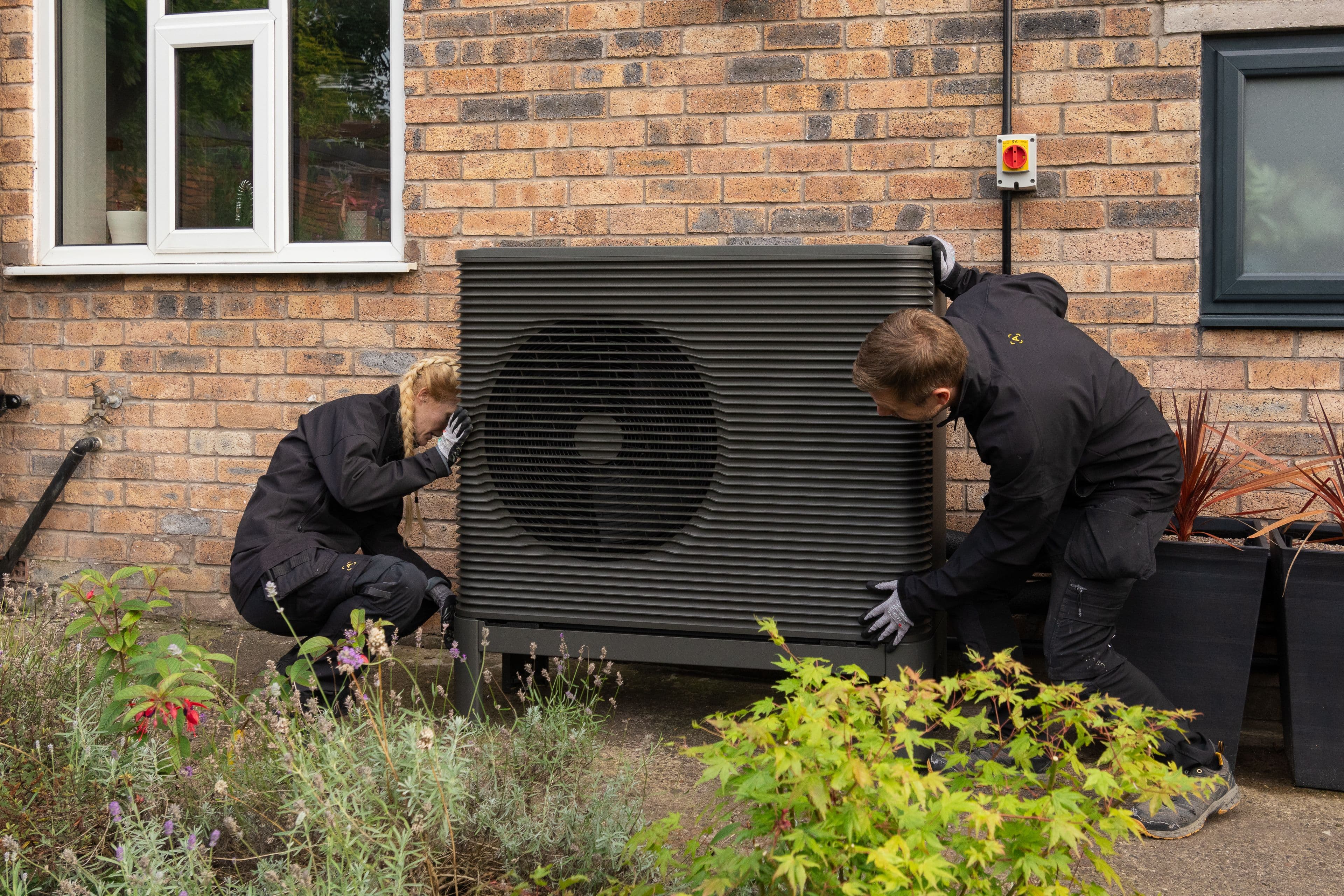 Two Aira Clean Energy Technicians installing an Aira Heat Pump