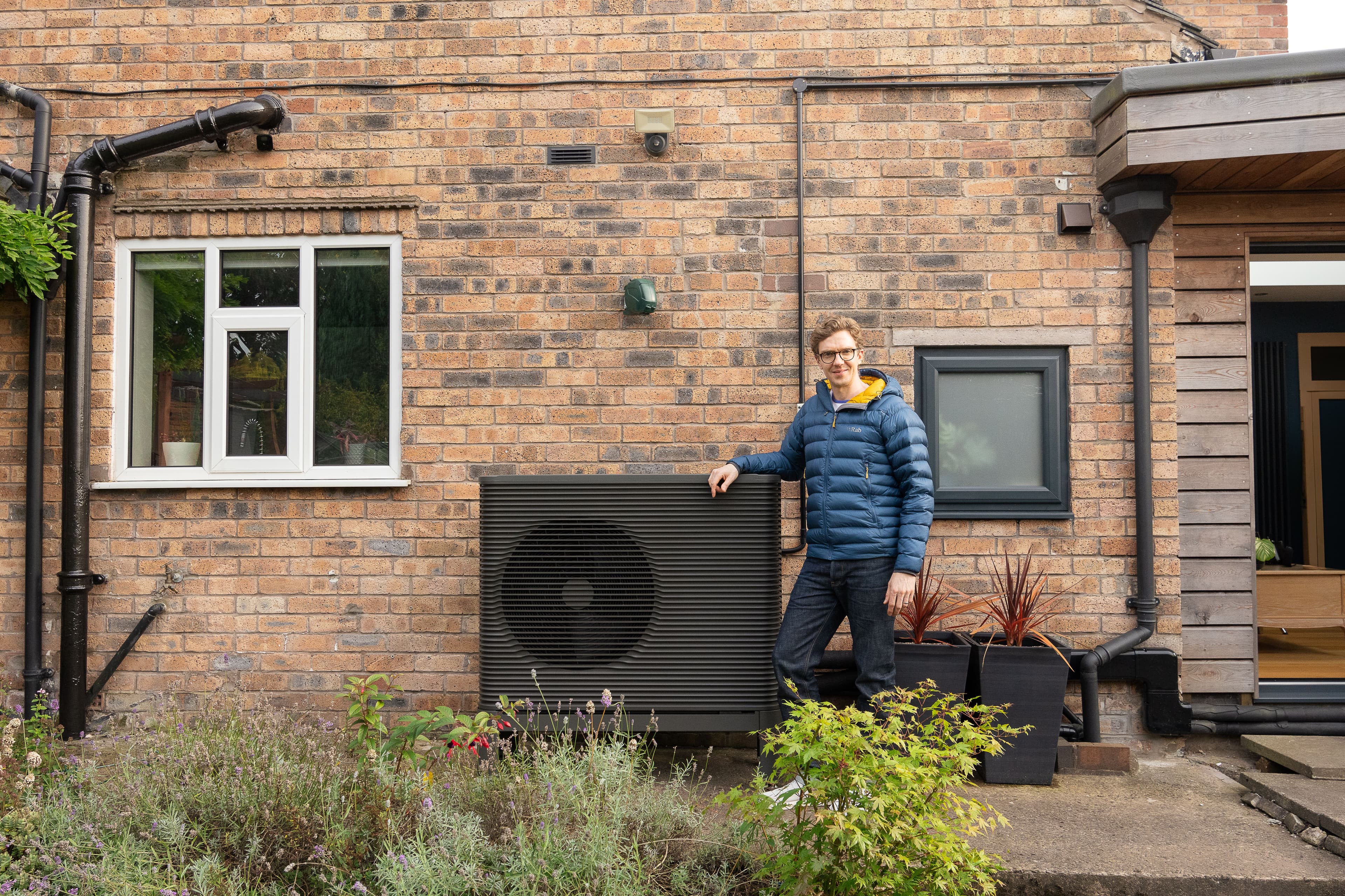 Aira Kunde vor der Wärmepumpe vor seinem Haus