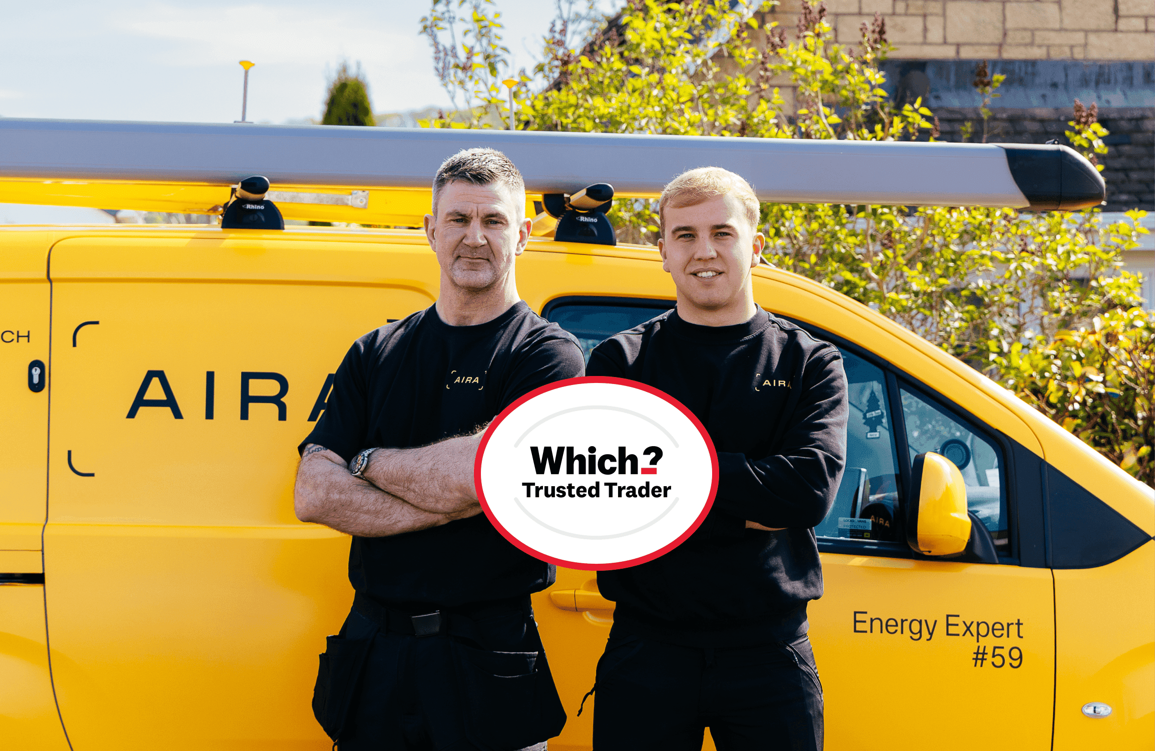Two Aira Heat Pump installers arms folded looking at camera which Which? Trusted Trader logo in front of them